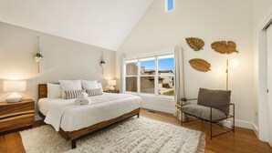 A bedroom with a bed, bedside tables, a chair, a window, and wall decorations. - Mid-century Mod Retreat Near Old Town – Free Bikes (Fort Collins)