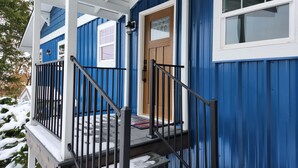 A blue building with a wooden door, a window, and a porch with a railing. - Cozy Lake and Mountain View House (Somers)