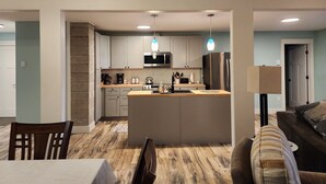 A modern kitchen with a central island, stainless steel appliances, and pendant lighting. - Cozy Lake and Mountain View House (Somers)