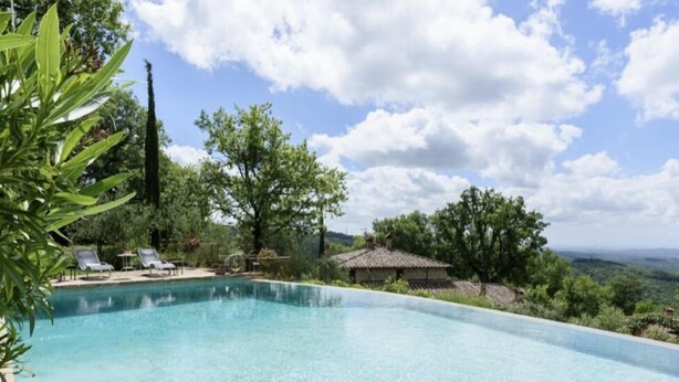 A clear swimming pool with lounge chairs and a view of a rural landscape. - Farmhouse with beautiful pool and jacuzzi, panoramic location in chianti (castellina in chianti)