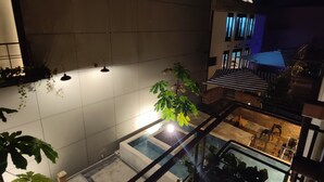 Un'area esterna moderna con piscina, piante in vaso e una scala che conduce a un livello superiore.