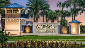 Der Eingang eines Resorts mit einem Schild, auf dem 'Windsor Island Resort' steht, sowie ein Gebäude mit blauem Dach und Balkonen.