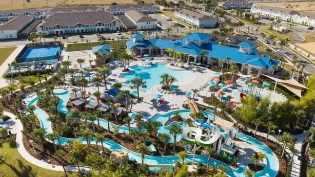 Ein Resort mit einem zentralen Pool, mehreren Wasserrutschen und Palmen.