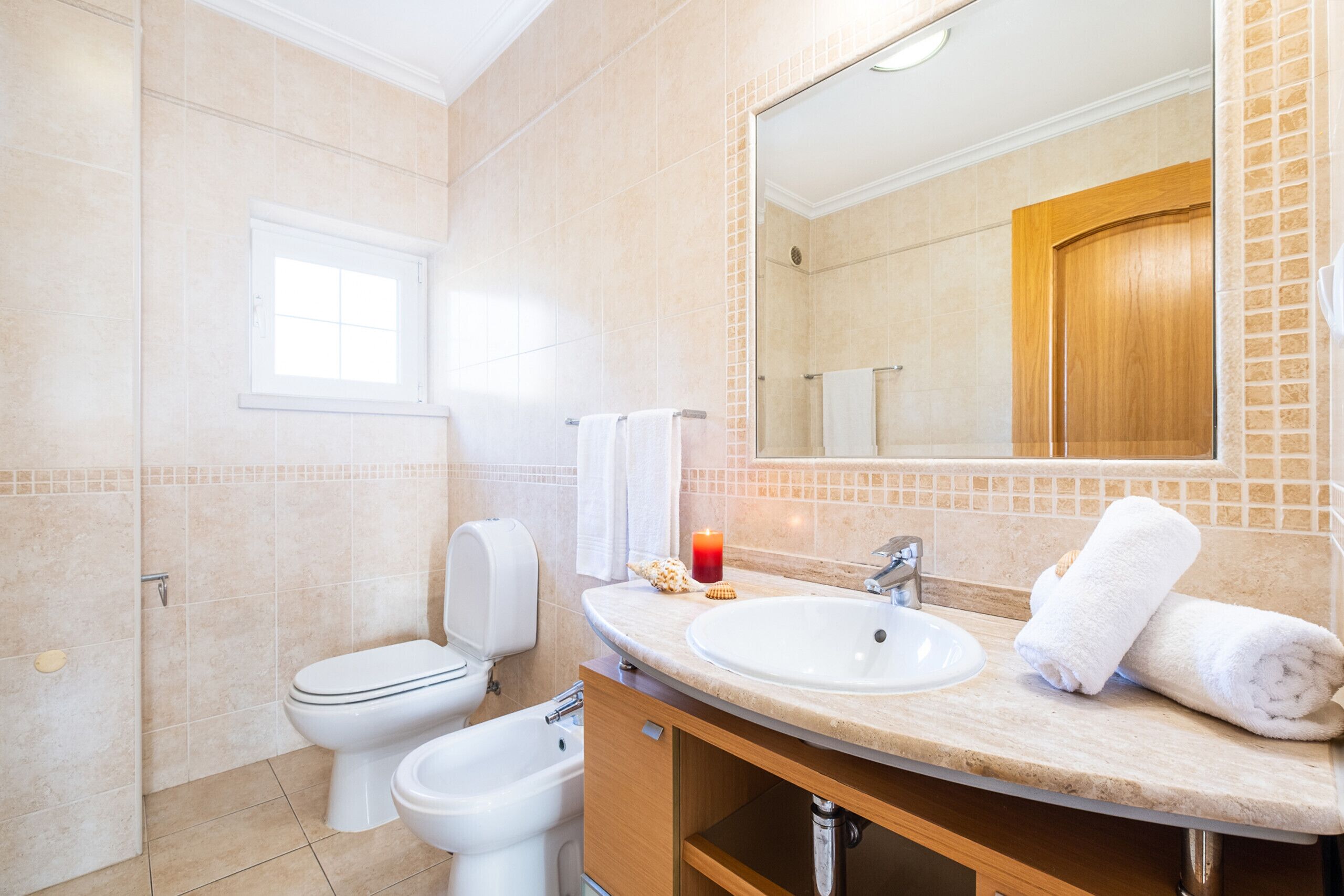 Ein Badezimmer mit Toilette, Bidet, Waschbecken und Spiegel.