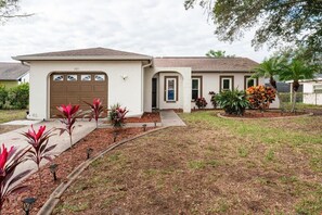 A single-story house with a garage, a front door, and a small porch area.