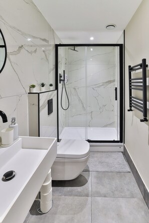 Habitación cuádruple de lujo | Baño | Cabezal de ducha tipo lluvia, secador de pelo, zapatillas y toallas