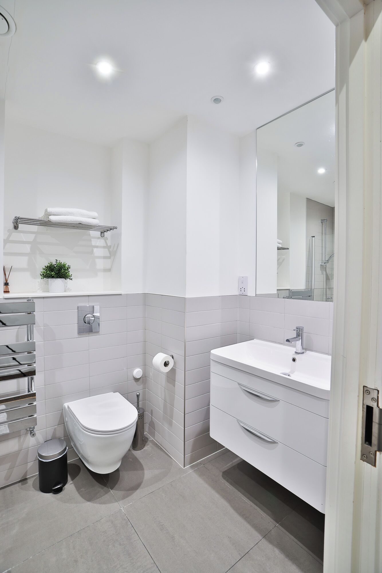 Une salle de bain moderne équipée de toilettes, d’un lavabo et d’un miroir.