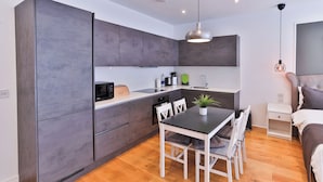 A compact kitchen with a microwave, sink, and modern pendant lighting. - Goodwin (London)