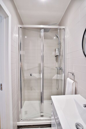 Basic Quadruple Room | Bathroom | Rainfall showerhead, hair dryer, slippers, towels - Goodwin (London)
