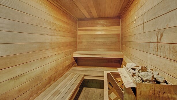 Un sauna avec des murs et des bancs en bois.