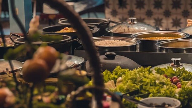 A buffet table with various food items and a decorative centerpiece.