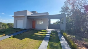 A modern two-story house with a flat roof, a front door, and a large window. - Casa Petronella (Pardinho)