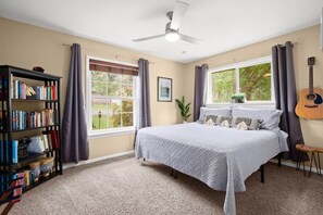 A bedroom with a bed, a bookshelf, a window with curtains, and a ceiling fan. - Secluded Half Acre Gem w/ Private Pickleball Court (Austin)