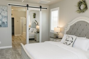 A bedroom with a bed, a nightstand, a dresser, a sliding door, and a wall-mounted wreath. - Fully-Furnished Home in Beaumont, CA (Beaumont)