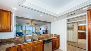 Una cocina moderna con armarios de madera, encimeras de granito y electrodomésticos de acero inoxidable.