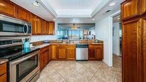 Una cocina moderna con armarios de madera, electrodomésticos de acero inoxidable y lavavajillas.