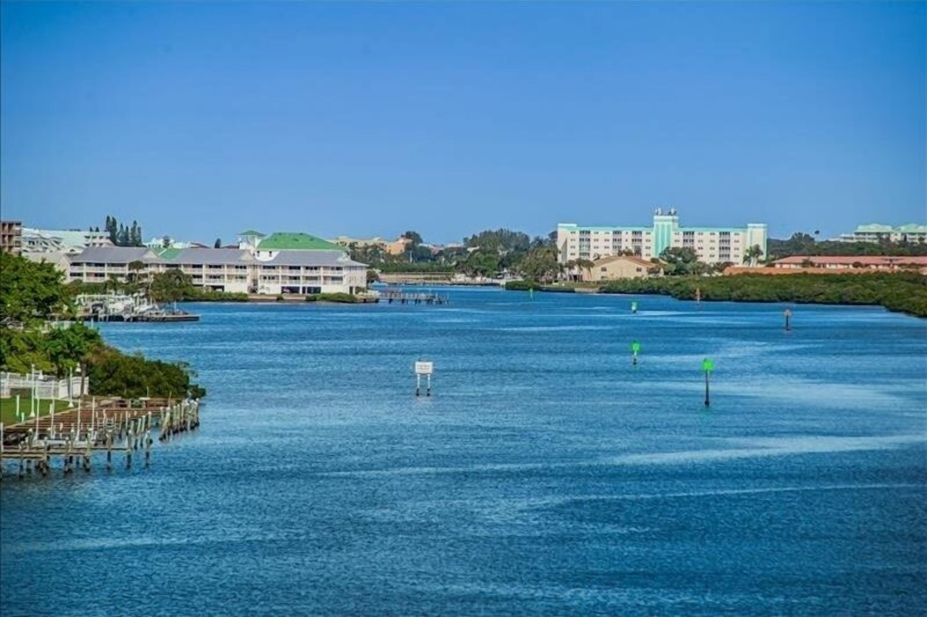 Ein Hotel am Wasserufer mit einer Marina, mehreren Gebäuden und blauem Himmel.