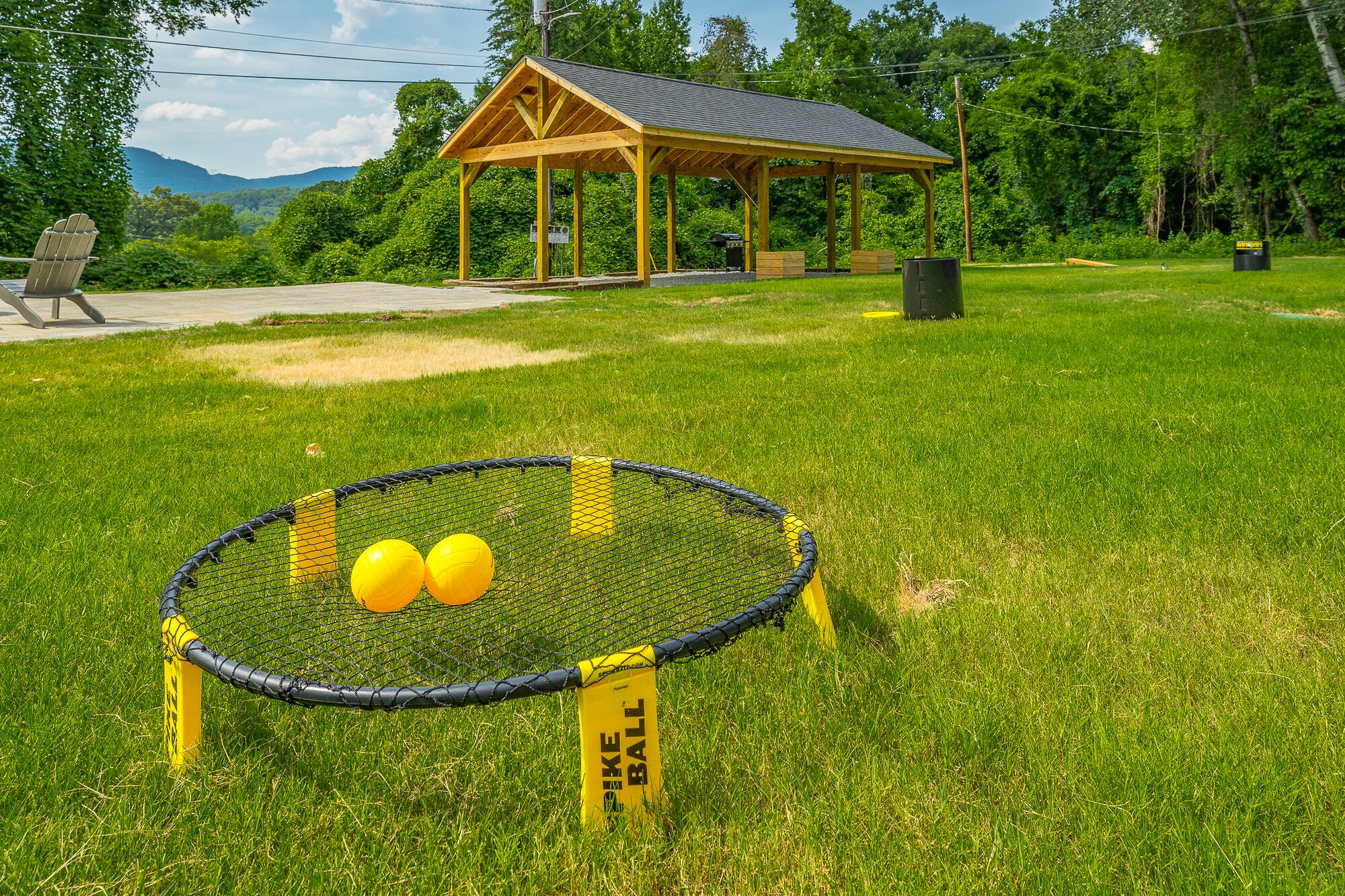 A sports field with a netted goal area and two yellow balls.