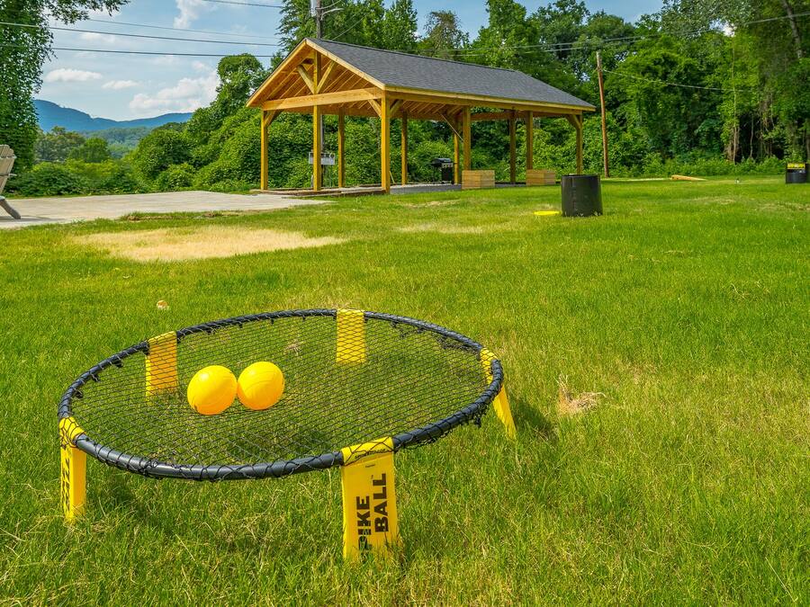 A sports field with a netted goal area and two yellow balls.