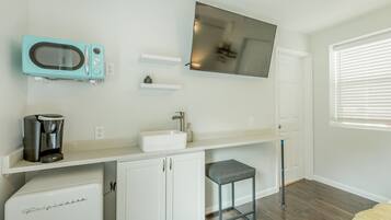 A compact kitchenette with a built-in microwave, coffee maker, and a small refrigerator.