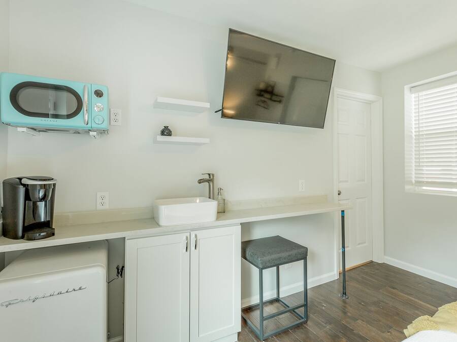 A compact kitchenette with a built-in microwave, coffee maker, and a small refrigerator.