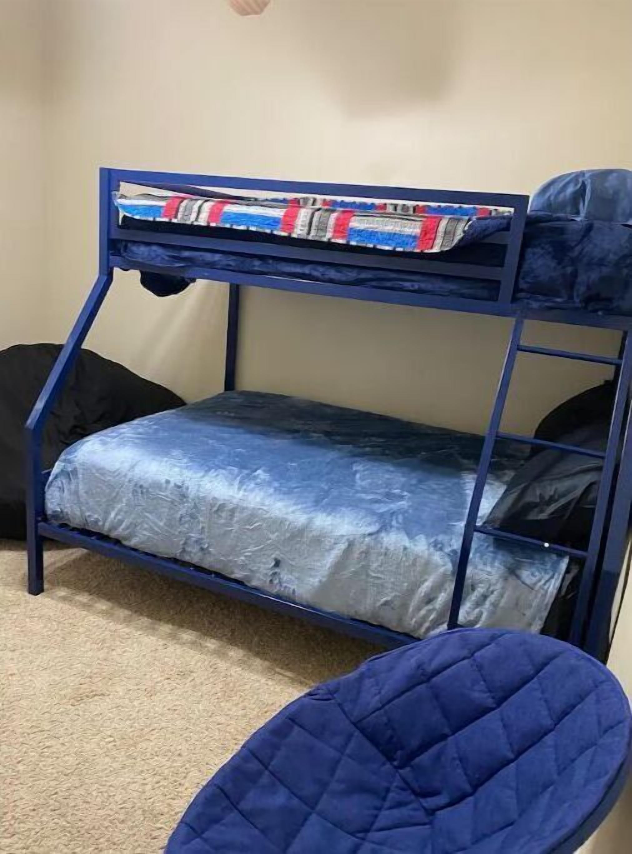 A bunk bed with a blue frame and a colorful blanket.