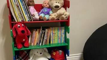 A bookshelf with books and stuffed toys.