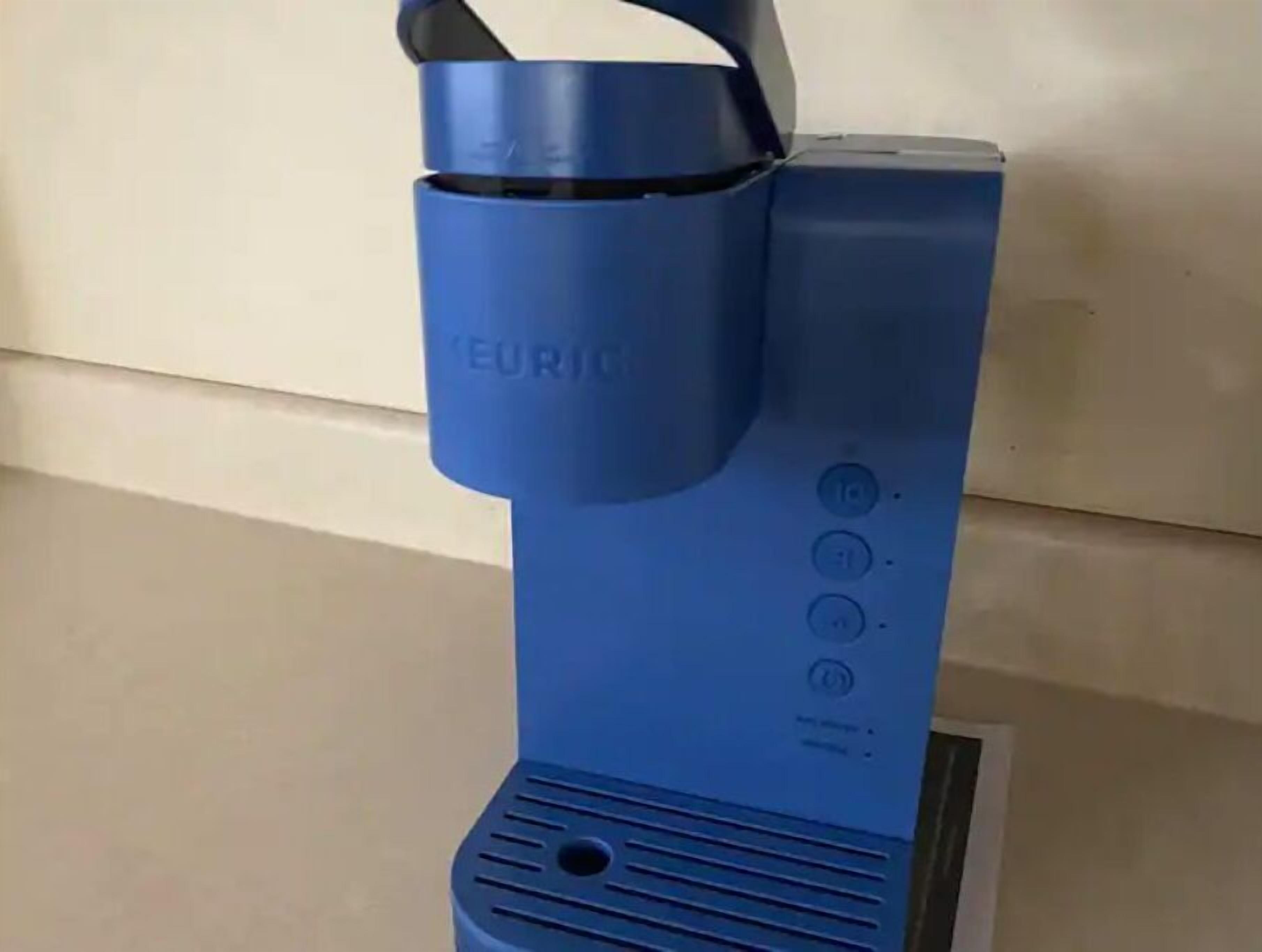 A blue electric kettle with a handle and buttons on the side.