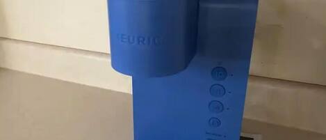 A blue electric kettle with a handle and buttons on the side.