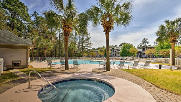 A swimming pool with a 3 ft depth marker, surrounded by lounge chairs and palm trees. - True Blue Golf Resort Condo - 3 Mi to Beach! (Pawleys Island)