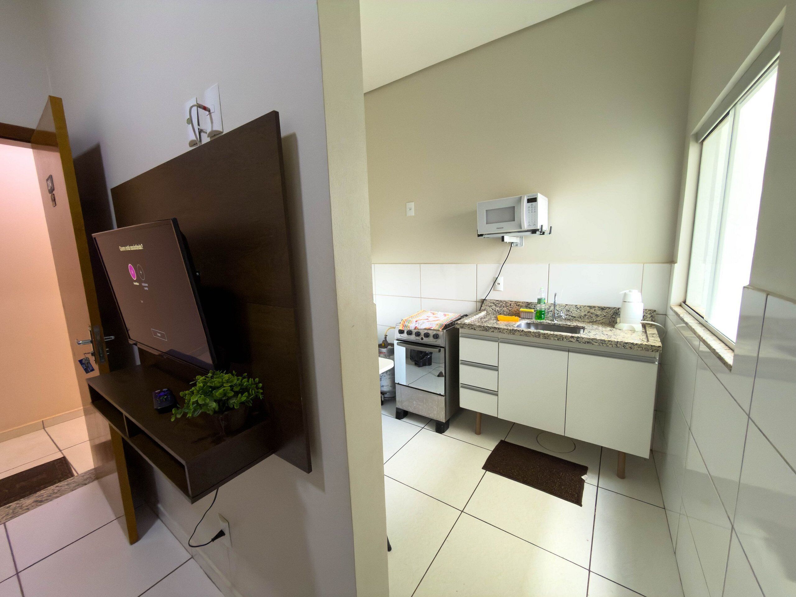 Une cuisine équipée d’un four à micro-ondes, d’un évier et d’une cuisinière.