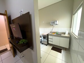 A kitchen with a microwave, sink, and stove. - CONDOMÍNIO SONHARE - 104 (Anapolis)