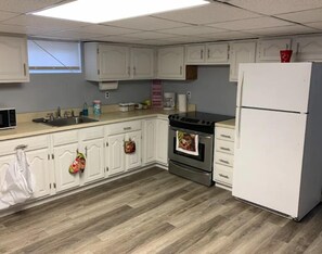 A kitchen with white cabinets, a stainless steel oven, a microwave, and a refrigerator.