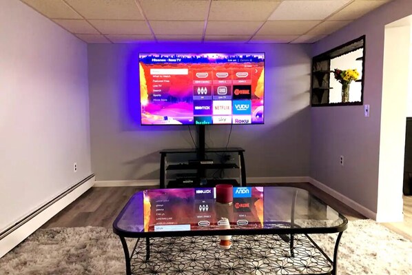 A flat-screen TV mounted on a wall displaying various streaming services.