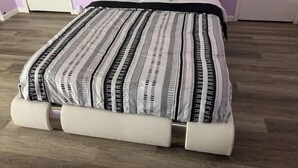 Un lit avec une couvre-lit à rayures et une tête de lit.