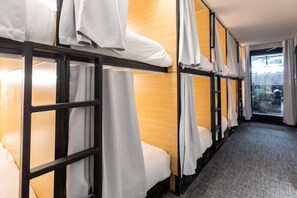 A hotel room with bunk beds, each with white bedding and curtains. - Parc Avenue Hostel (Montreal)