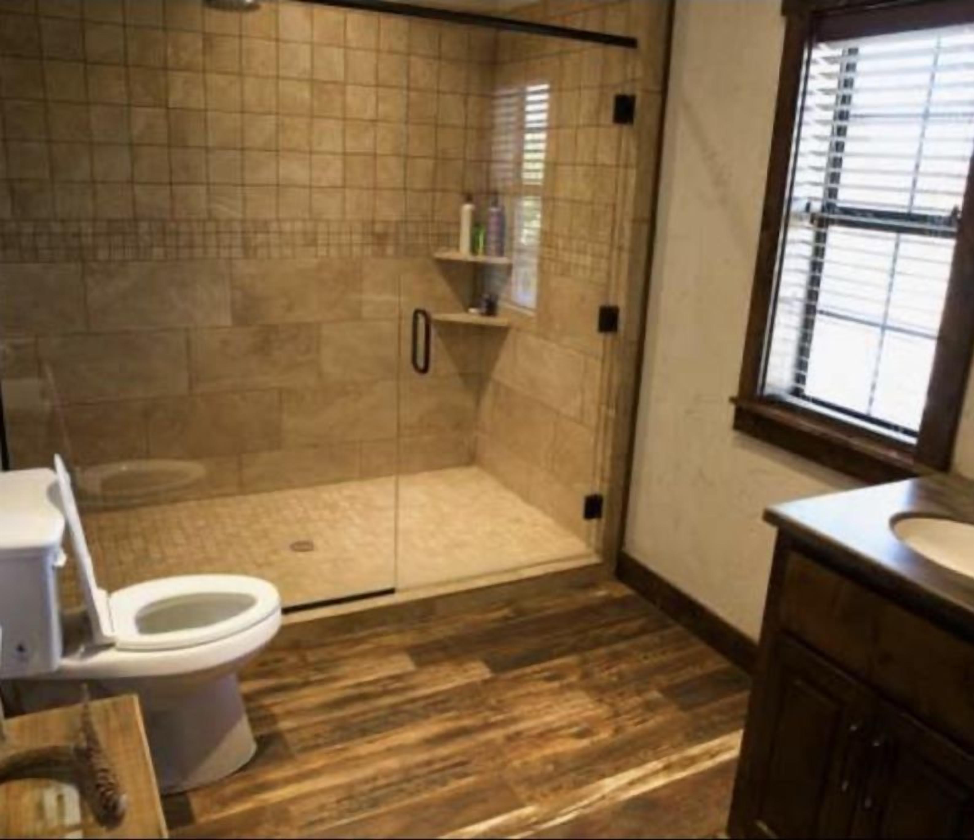 A bathroom with a shower, toilet, and sink.