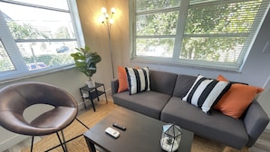 A modern living room with a gray sofa, a brown chair, a coffee table, and a floor lamp. - 2655 SW - APT 3 · Great Apart near CocoWalk & Brickell w/parking! (Miami)