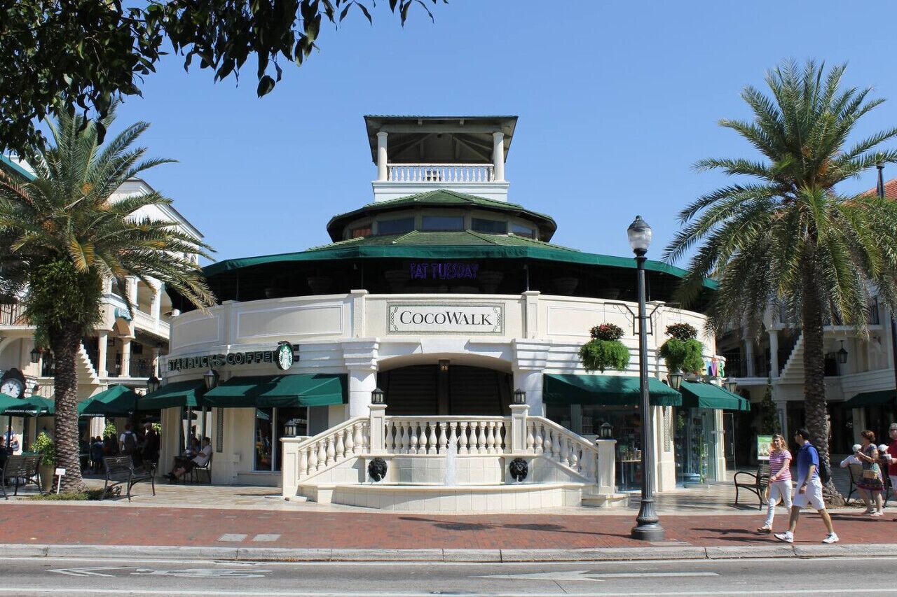 A building with a sign reading "Cocowalk" and a Starbucks Coffee shop on the ground floor.