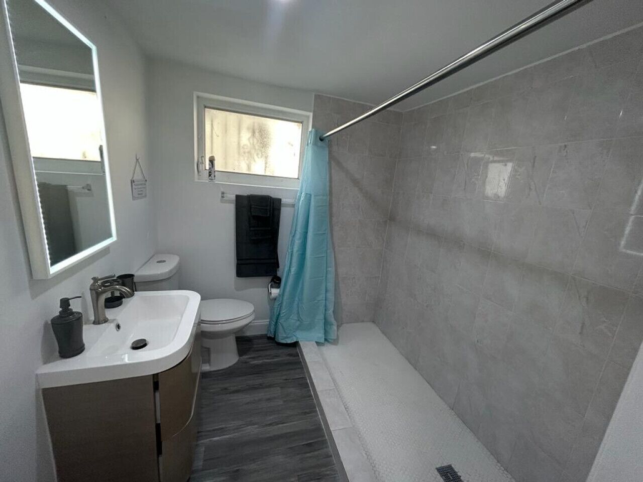 A modern bathroom with a white sink, toilet, and bathtub.