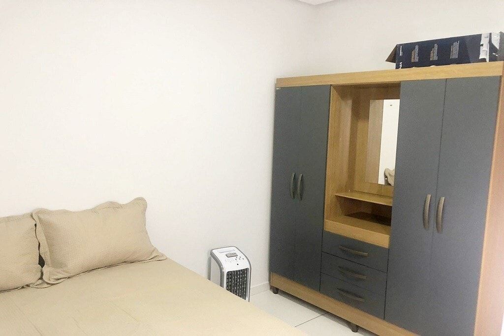 Een slaapkamer met een bed, een kledingkast en een verwarming.