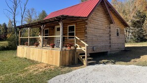 A wooden cabin with a red roof, a porch with potted plants, and a gravel driveway. - The Stillhouse Cabin, mins from Red River Gorge (Campton)
