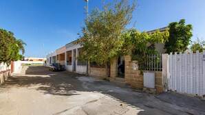 A residential street with houses, a parked car, and a tree. - 3137 Villetta Velia by Barbarhouse (Porto Cesareo)