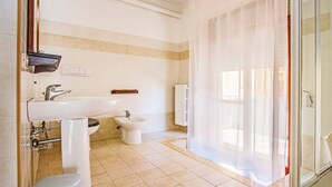 A bathroom with a sink, toilet, bidet, and shower area. - Mammasisi (Lecce)