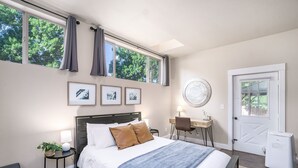 Une chambre à coucher comprenant un lit, un bureau, une chaise, un radiateur et une porte.