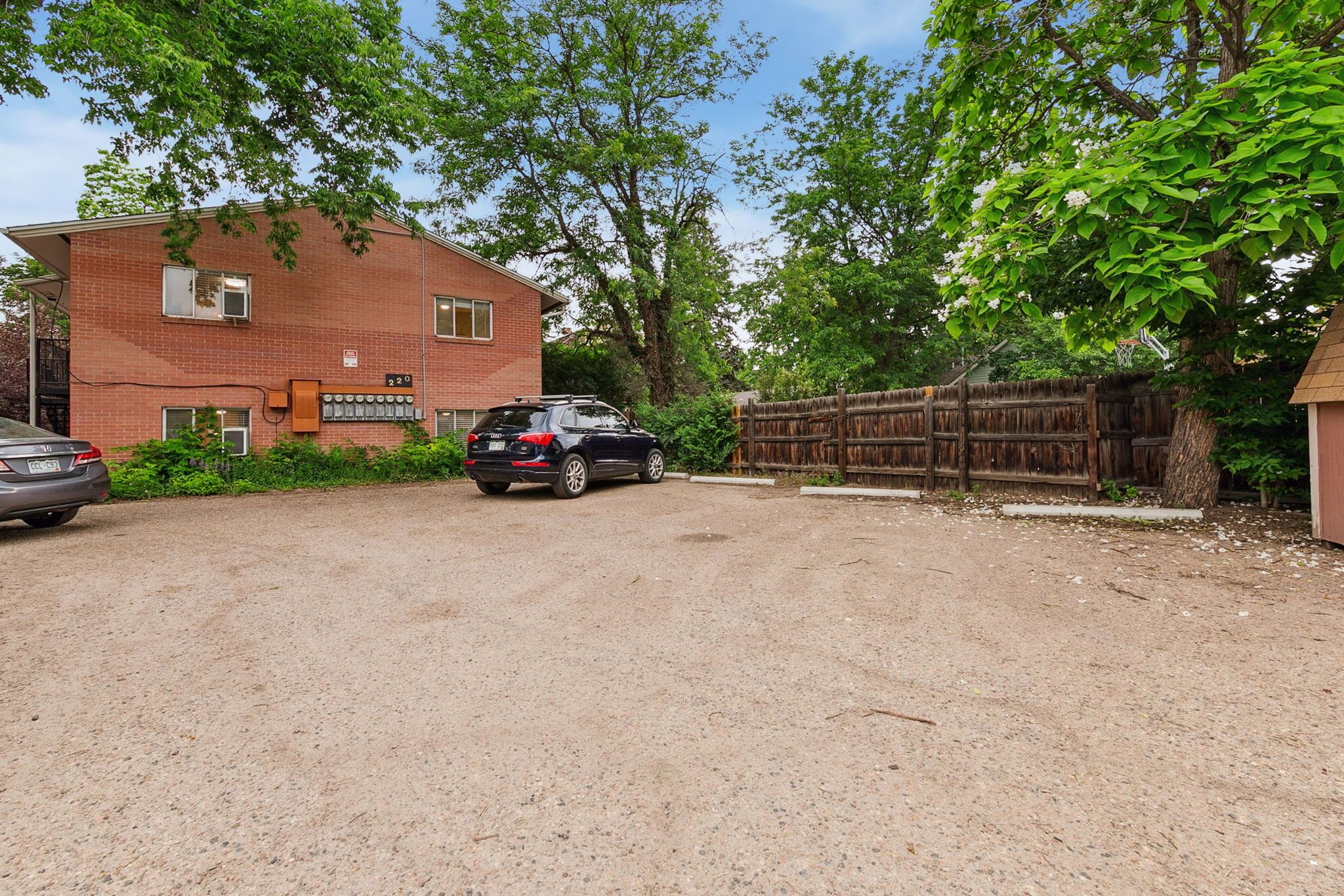 A brick building with a garage and a dirt driveway.