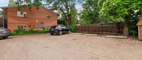A brick building with a garage and a dirt driveway.