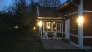 Il s’agit d’un bâtiment à la façade en briques et au toit recouvert de tuiles. Il y a deux espaces extérieurs aménagés avec des chaises et une table.