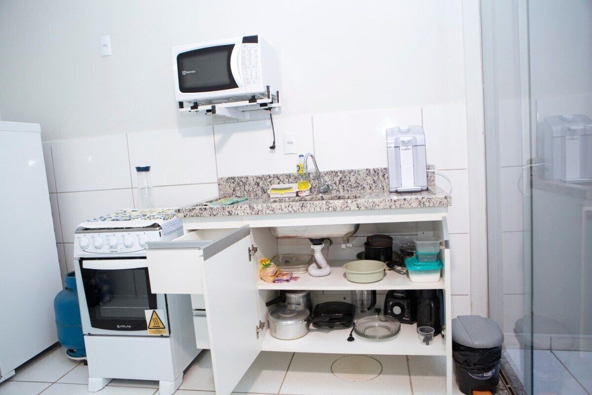 A kitchen with a microwave, stove, and various kitchen items on the counter.