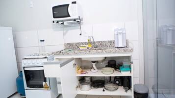 A kitchen with a microwave, stove, and various kitchen items on the counter.
